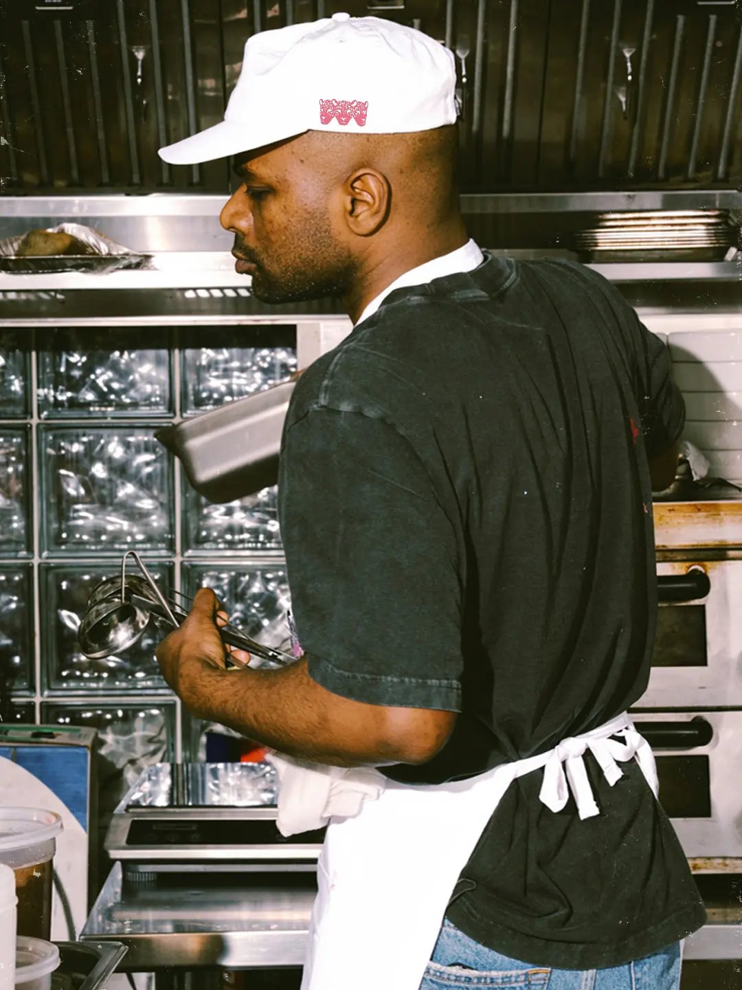 Poco A Poco chef working and wearing merchandise