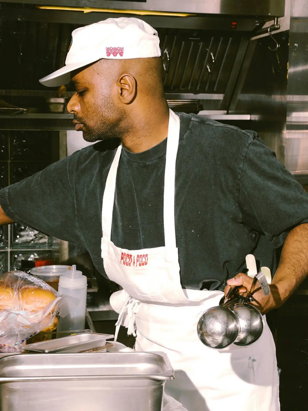 Poco A Poco chef working and wearing merchandise