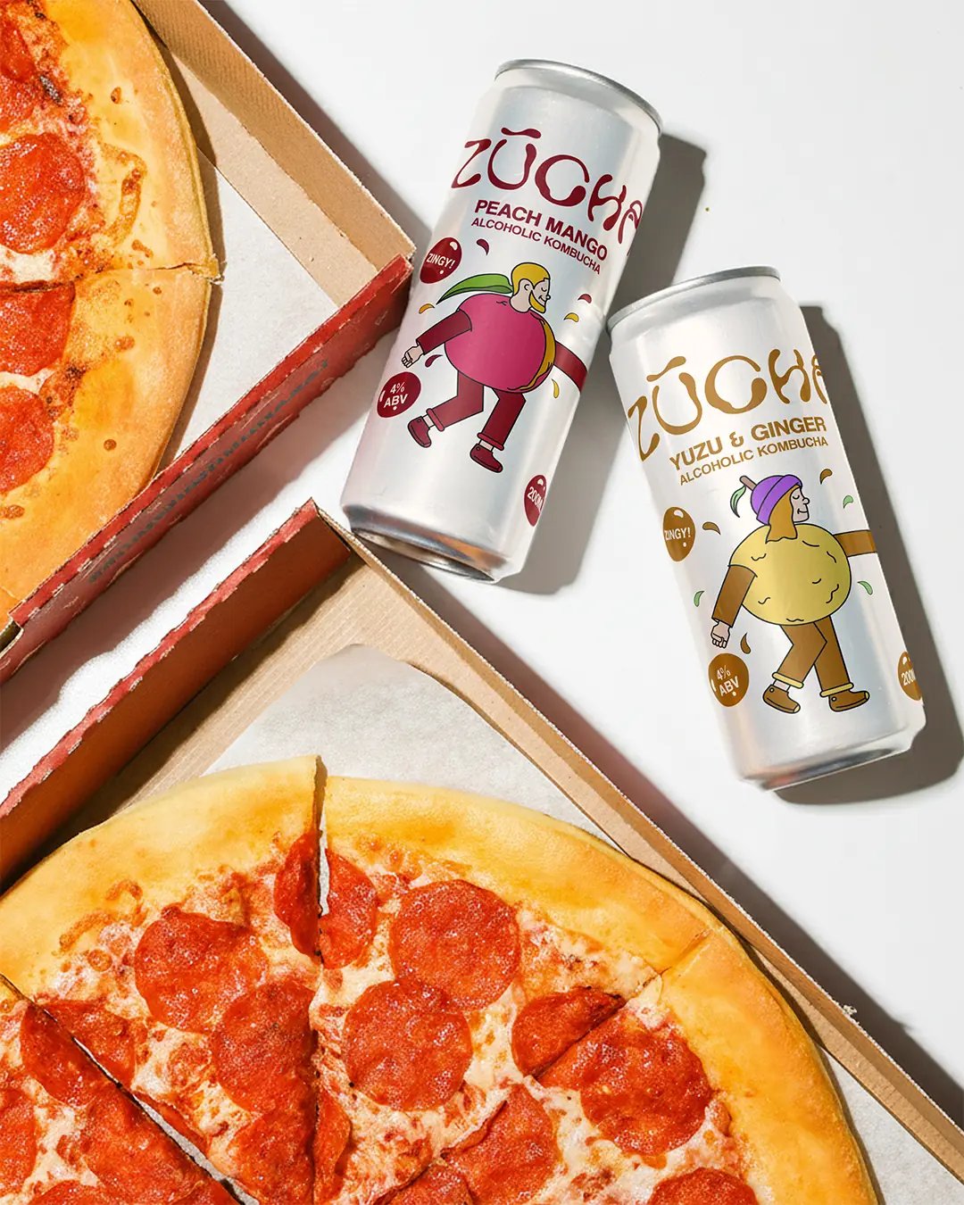 ZŪCHA Cans Next to Pizza